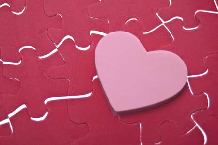 Love is a Puzzle Concept Image with a Puzzle and Pink Heart.の写真素材