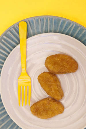 Chicken Nuggets on a Modern Place Setting with a Yellow Fork.の写真素材