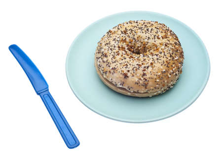 Everything Bagel on a Plate with a Knife. Isolated on White の写真素材