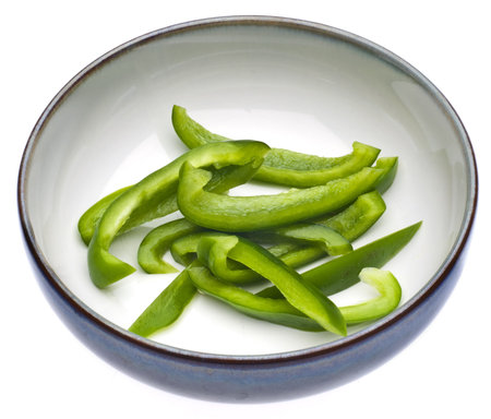 Fresh Green Bell Pepper Slices in a Bowl Isolated on White の写真素材