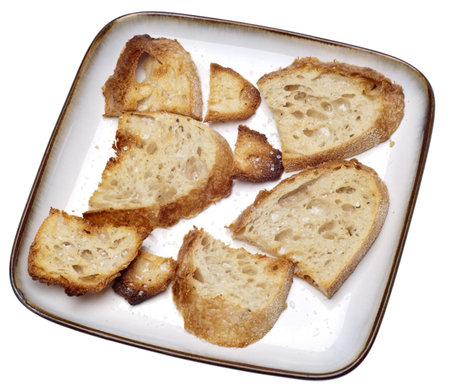 Pieces of Toasted Bread with Salt on a Plate Isolated on White