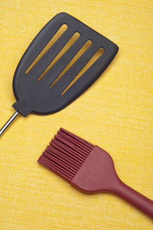 Kitchen Cooking Concept with Spatula and Cooking Brush on Yellow.の写真素材