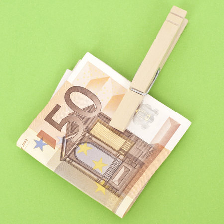 Euro Currency in a Clothespin on Vibrant Green.  Money Concept.