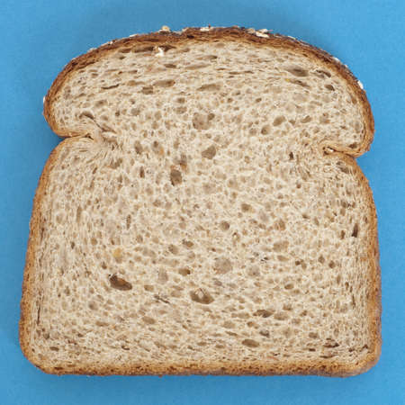 Fresh Healthy Slice of Whole Grain Bread on Vibrant Blue.の写真素材
