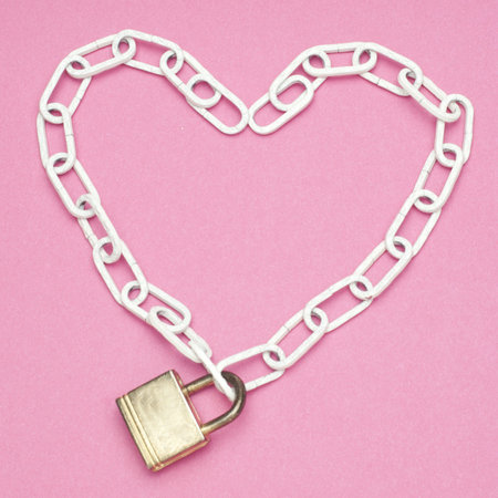 Love and Security Concept with Lock and Chain Heart on a Pink Background.の写真素材