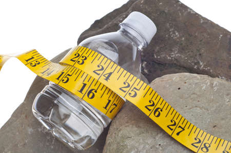 Diet and Fitness Concept with Bottle of Water on Rocks and Measuring Tape.の写真素材