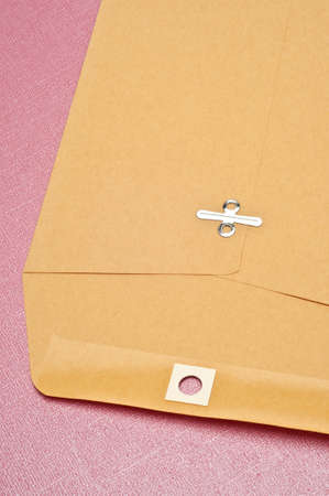 Plain Brown Envelope on a Pink Background.の写真素材