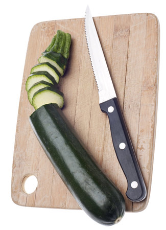 Sliced Zucchini on a Wooden Chopping Block Isolated on White の写真素材