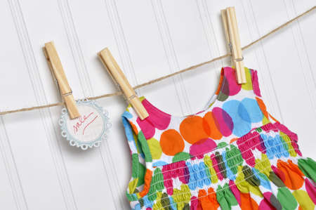 Vibrant Polka Dot Baby Dress on a Clothesline with Handwritten Sale Sign.の写真素材