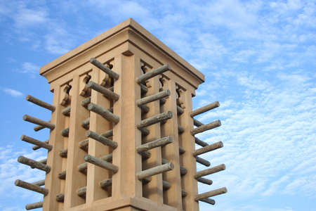 an arabic wind tower against a cloudy skyの写真素材