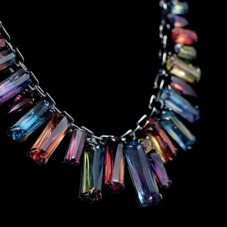 Necklace with multicolored stones on a black background.の素材