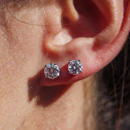 Diamond earrings in the ear of a young woman close-upの素材