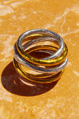 wedding rings on the table in the sun, closeup of photoの素材