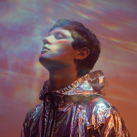 Portrait of a beautiful young man in a shiny silver jacket.の素材