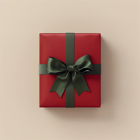 Red gift box with green bow on beige background, top viewの素材