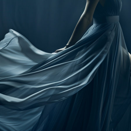 Silhouette of a beautiful woman in a blue dress on a dark backgroundの素材