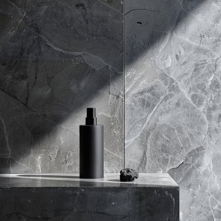 Black cosmetic bottle mockup on gray marble background. 3d renderingの素材