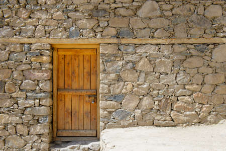 Old wooden door on stone wallの写真素材