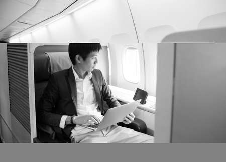 Asian businessman using laptop on first class cabinの写真素材