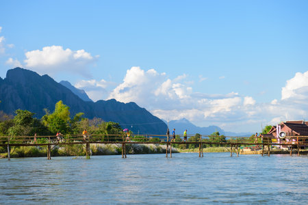 Vang Vieng, Laos - November 13, 2014 : Toursit activies with wooden bridge over Song river in Vangvieng, Vang Vieng is a tourist attraction town in northern Laosのeditorial素材