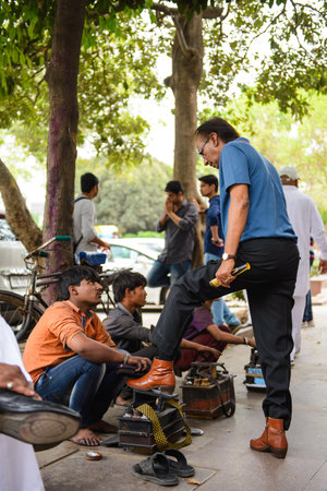 New Delhi, India - April 10, 2016 : Unidentifie professional street sweeper shoes with customers in New Delhiのeditorial素材