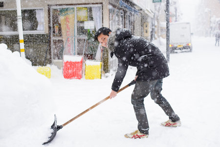 Takayama, Japan - January 16,2017 : Japanese man with snow shovel removing snow on the road in winter time at Takayama old townのeditorial素材