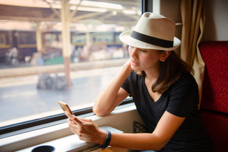 Young asian woman using smart phone while traveling by train