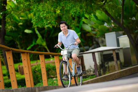 Young asian man riding a bicycle in a park