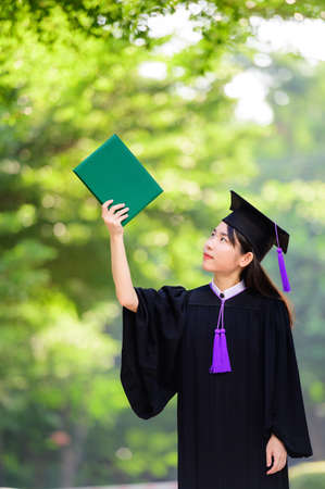 Pretty asian female holding diplomasの写真素材