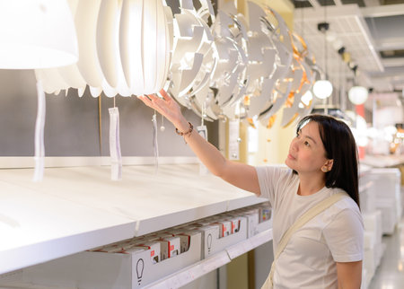 Asian woman choosing lighting for her home