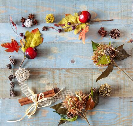 background with autumn leaves with heart shape laid on a dark blue background, also useful image for a Christmas styleの写真素材