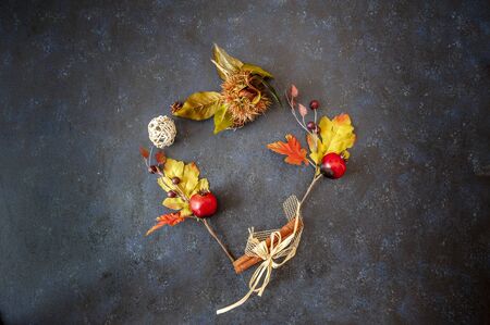 background with autumn leaves with heart shape laid on a dark blue background, also useful image for a Christmas styleの写真素材
