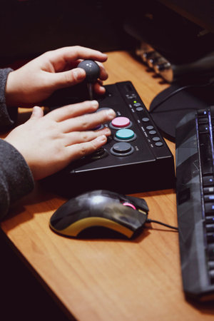 Imperia, Italy, 20/11/2019: hands of a young boy who in the house plays with video games and joystick from vintage arcadeの写真素材