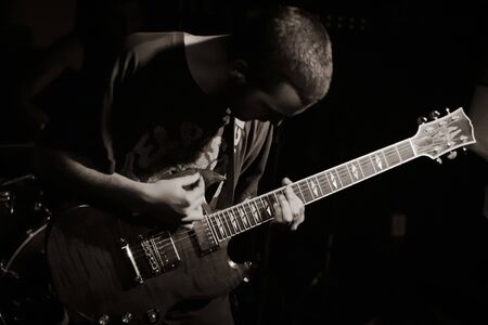 guitarist in concert on dark backgroundの写真素材