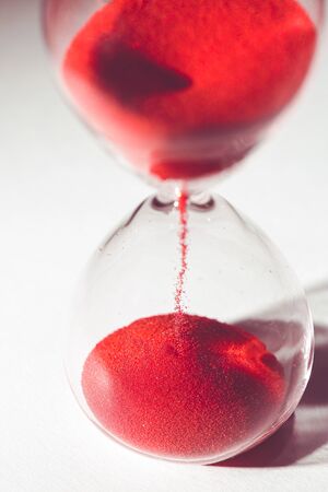 isolated hourglass with red sandの写真素材