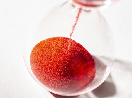isolated hourglass with red sandの写真素材