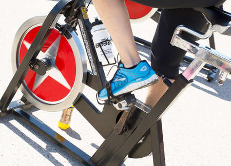 Legs moving during a workout of spinning -----Imperia, IM, Italy - May 18, 2014: People perform a spinning session outdoors in an urban park of liguria. Athlets training an their special bikers to keep healthyのeditorial素材