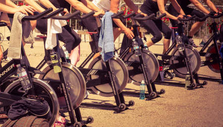 Legs moving during a workout of spinning -----Imperia, IM, Italy - May 18, 2014: People perform a spinning session outdoors in an urban park of liguria. Athlets training an their special bikers to keep healthyのeditorial素材