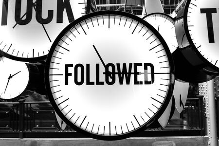 black and white photos with a large clock with the inscription "FOLLOWED"の写真素材