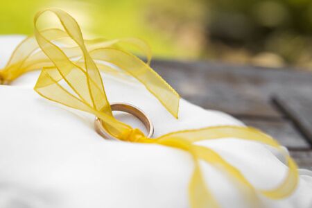 Wedding rings resting on a white pillow.の写真素材