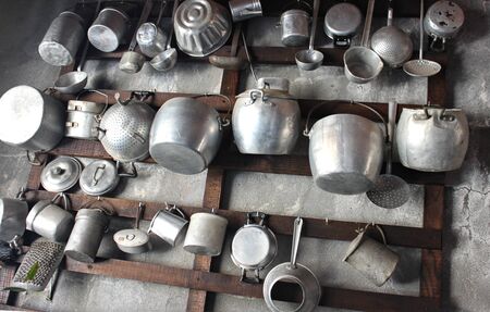Ancient pots in iron hanging on the wallの写真素材