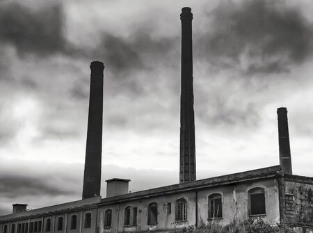 ancient factory with stone towers and dramatic skyの写真素材
