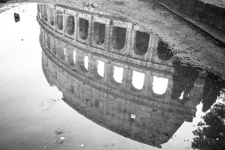 Rome, Italy, 11/27/2019: The ancient colosseum of rome reflected in the water, travel reportage