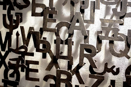 Metal letters attached to a wall form an artistic patternの写真素材