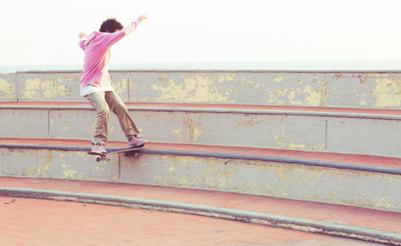 Imperia, IM, Liguria, Italy - 29/02/2018: A young boy jumping on the skateboard in a square during a...