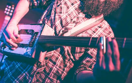 Musician playing a strange rectangular guitar built by himselfの写真素材