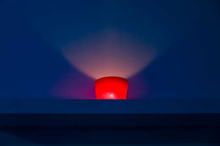 red candle on blue background inside a spaの写真素材