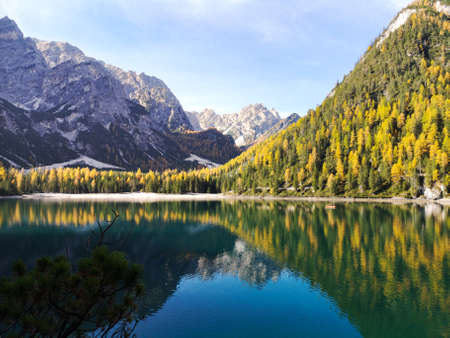 Italy, Trentino Alto Adige: natural landscape of Braies Lake with green trees, lake with reflection and mountain with snowの写真素材