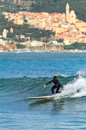 surfer rides the ligurian wave during a winter dayの写真素材