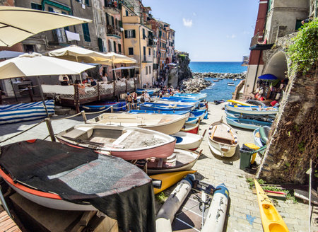 Ligurian town of Manarola with tourists and moored boatsのeditorial素材